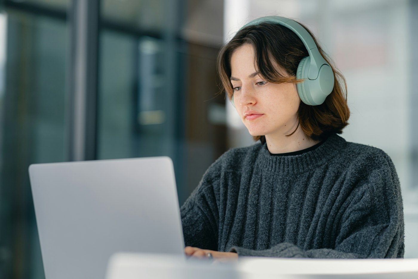Woman learning online with laptop and headphones
